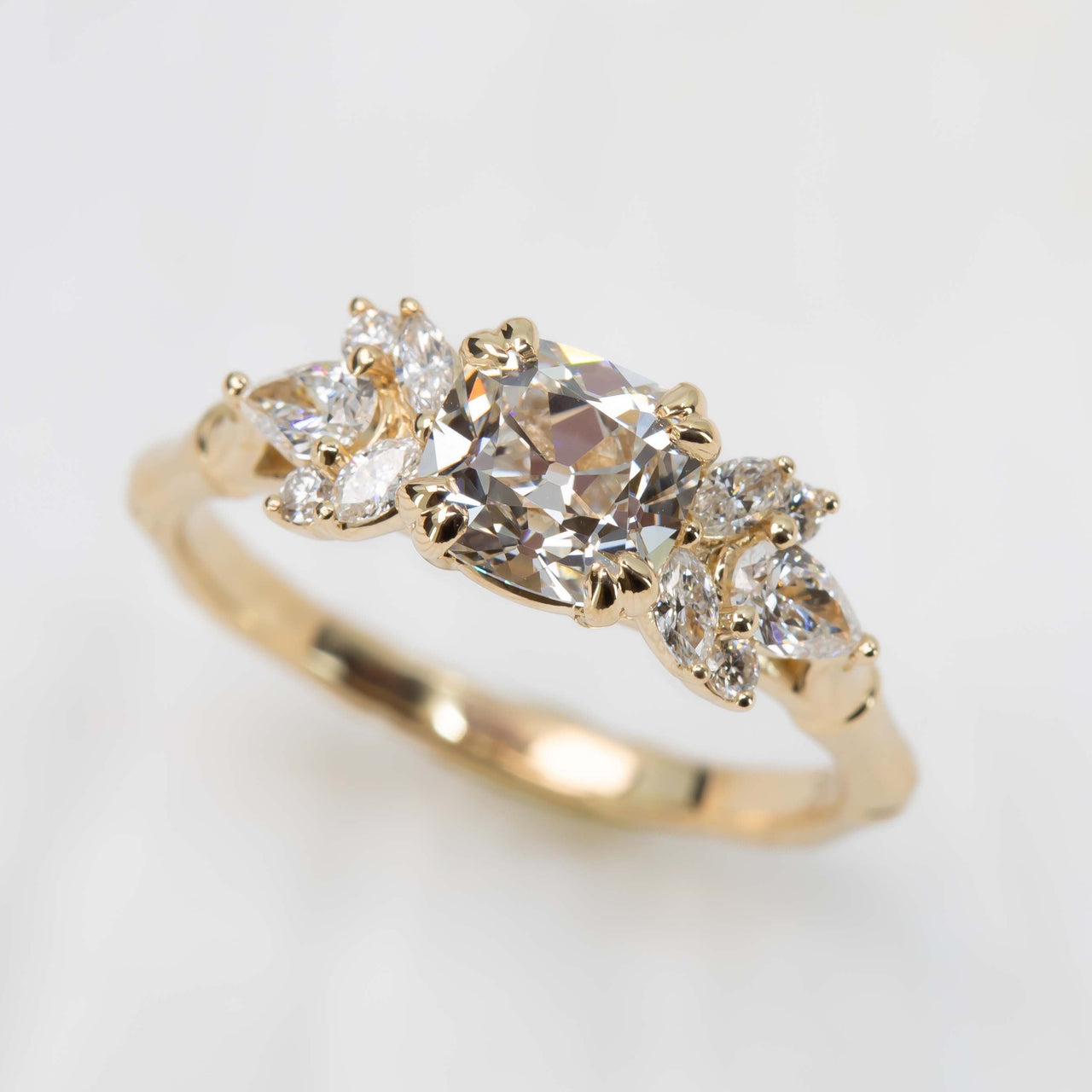 Gold ring with three diamonds on a light gray background