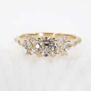 Gold ring with three diamonds on a light background