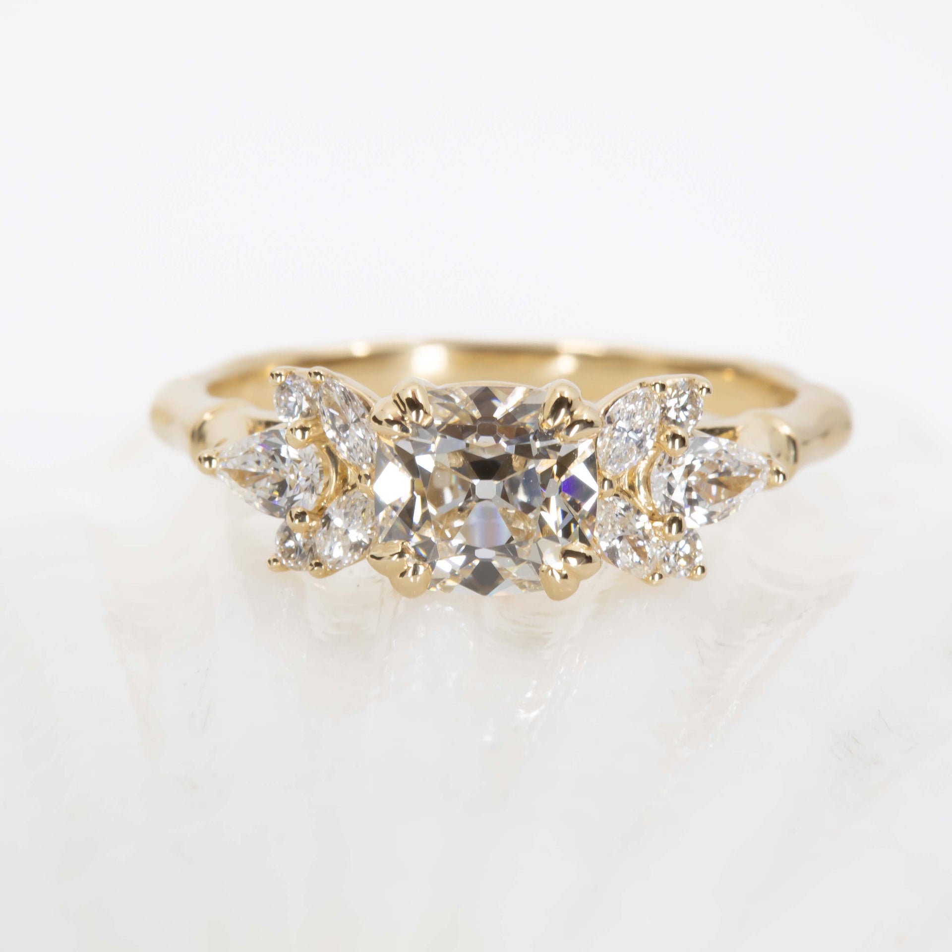 Gold ring with three diamonds on a light background