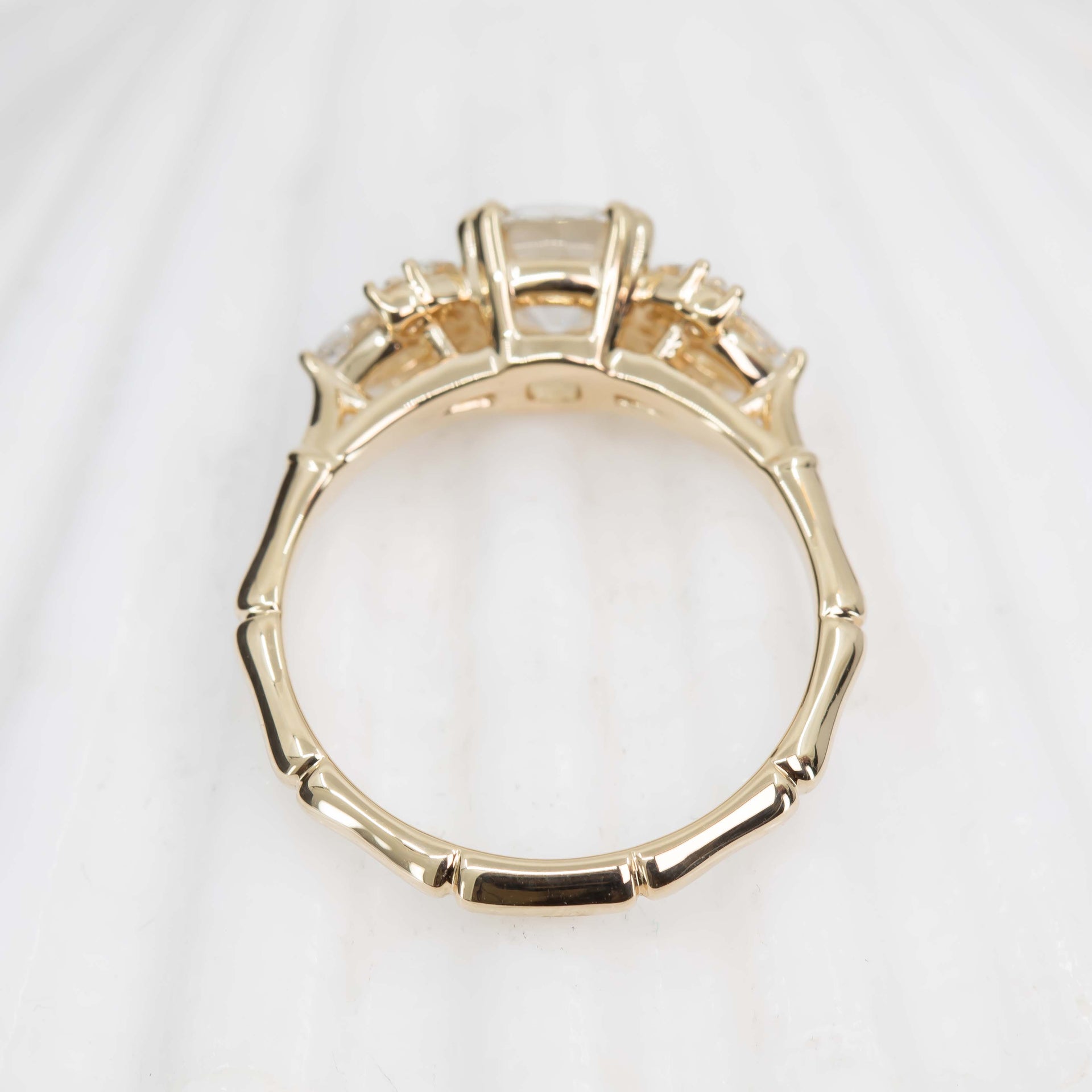 Gold ring with a bamboo design on a white background