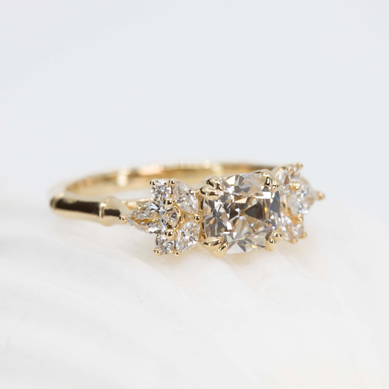 Gold ring with three diamonds on a light background
