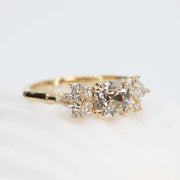 Gold ring with three diamonds on a light background