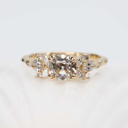 Gold ring with three diamonds on a light background