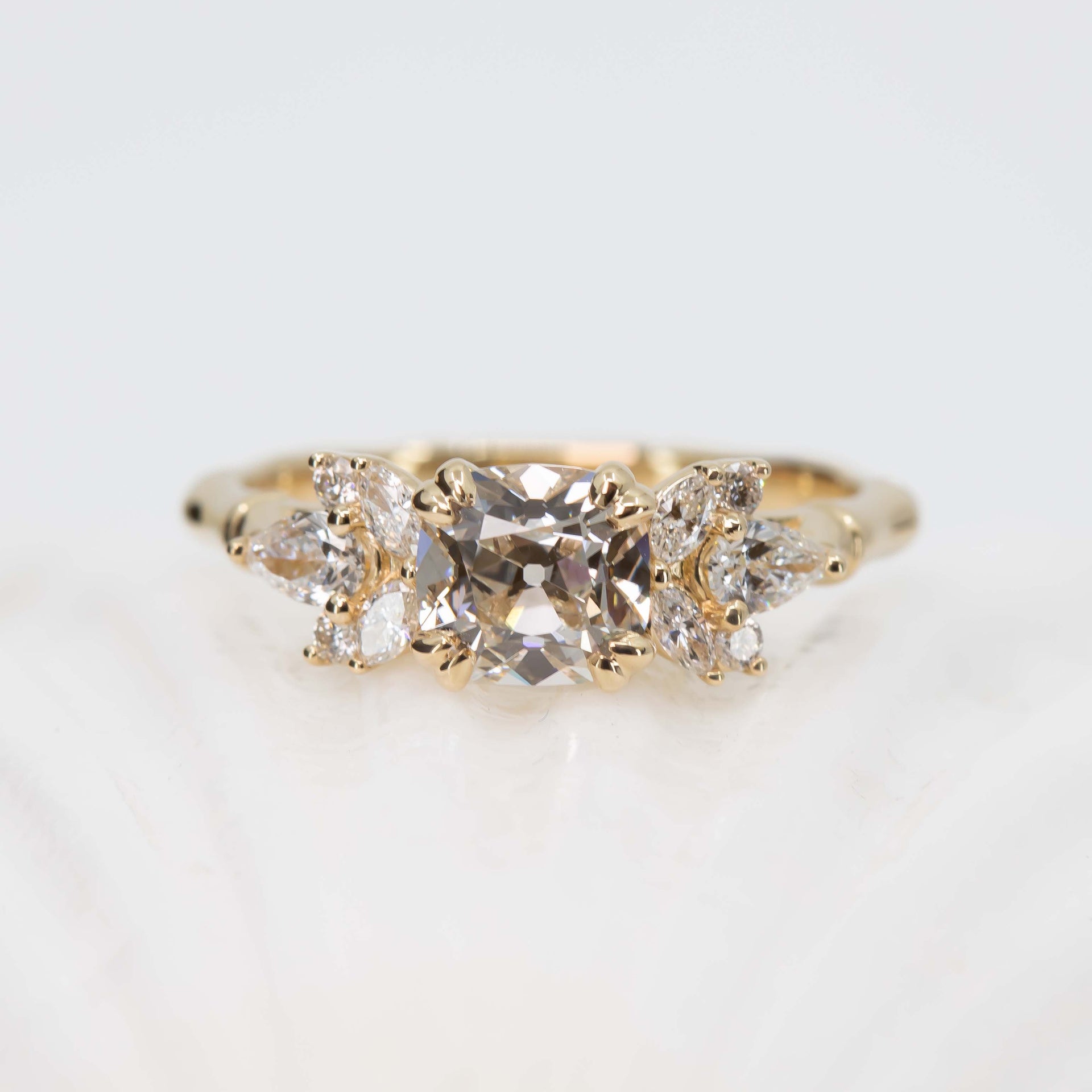 Gold ring with three diamonds on a light background