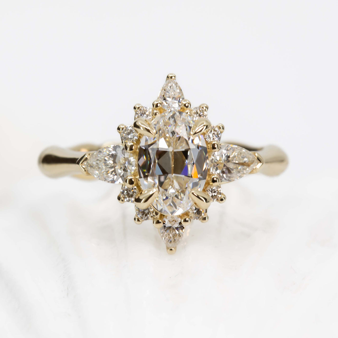 Gold ring with diamond cluster on a light background