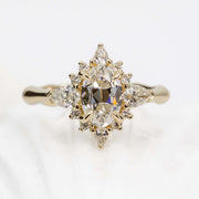 Gold ring with diamond cluster on a light background