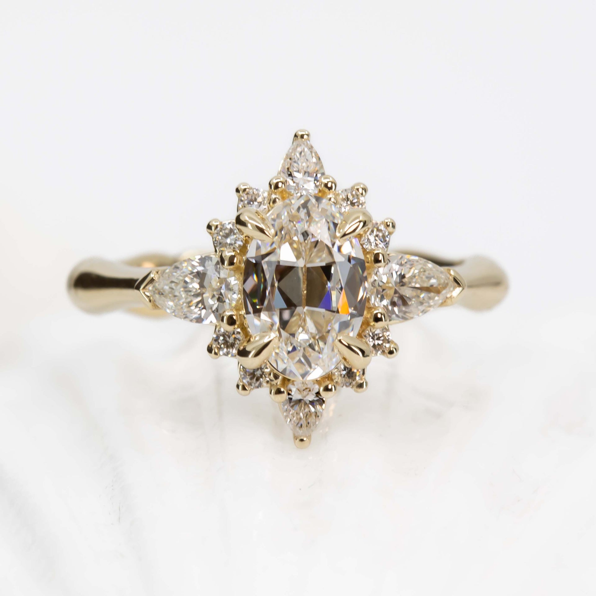 Gold ring with diamond cluster on a light background