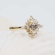 Gold ring with a diamond cluster on a light background