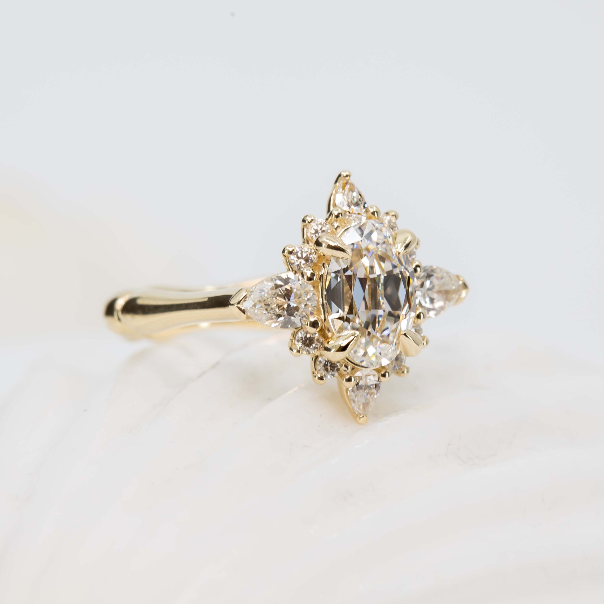Gold ring with a diamond cluster on a light background