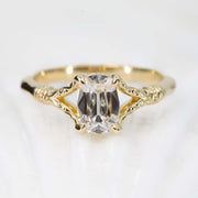 Gold ring with a diamond on a light gray background