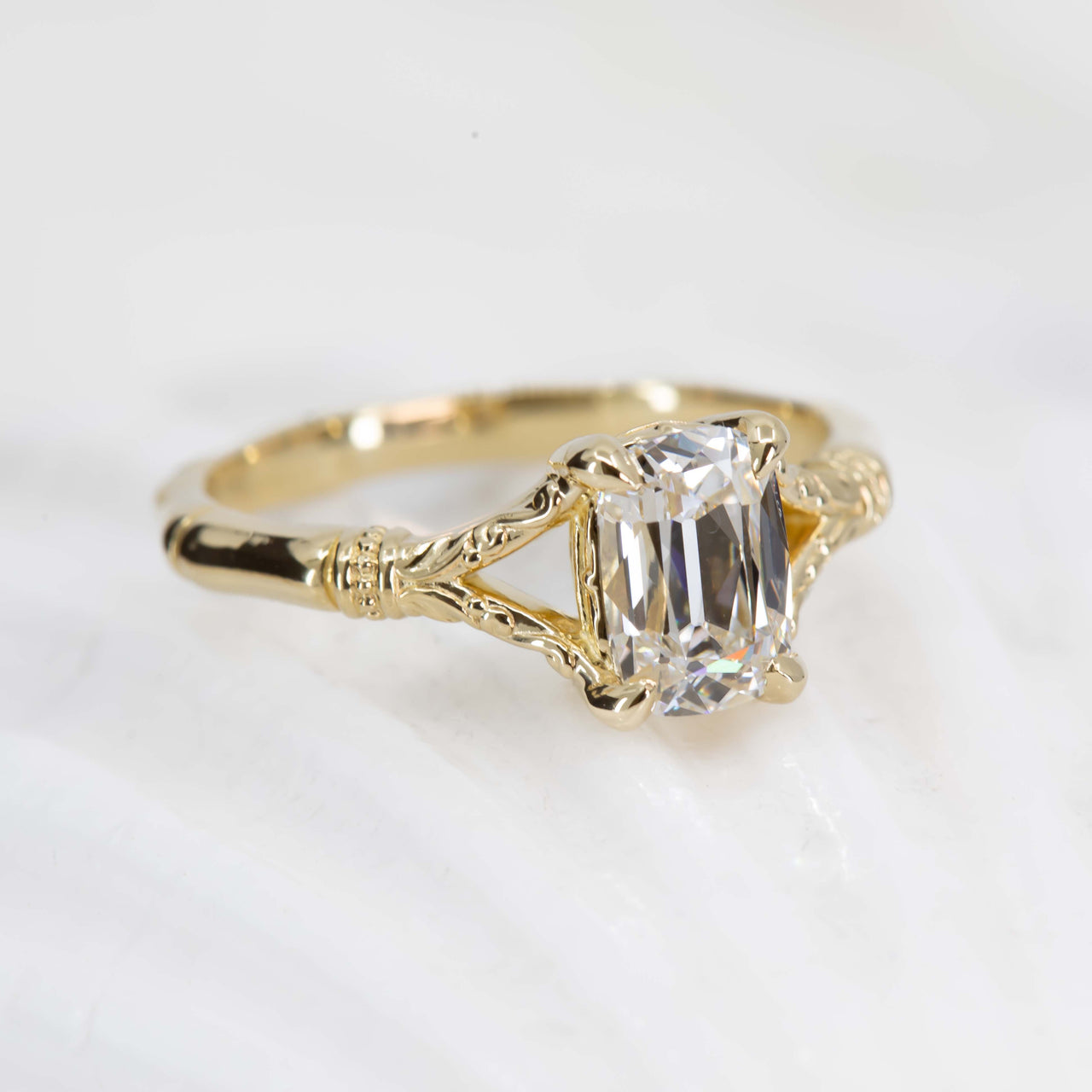 Gold ring with a clear gemstone on a white background